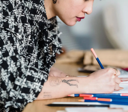 Personne dessinant avec des crayons de couleur sur un carnet